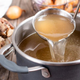Broth being ladled from pot